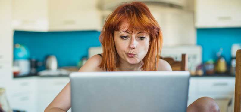 Person looking at laptop and thinking.