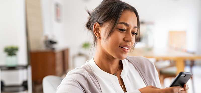 A person holding a mobile phone and looking at it.
