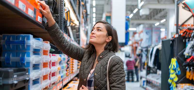 A person shopping in an aisle of a home-improvement store.
