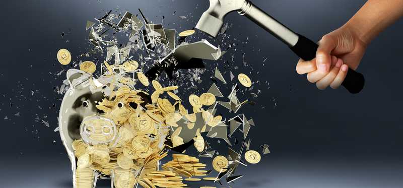 Person smashing a piggy bank with a hammer.