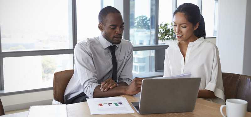 Professional man and woman reviewing documents together.