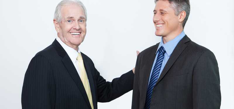 Professional man patting another professional on the shoulder.