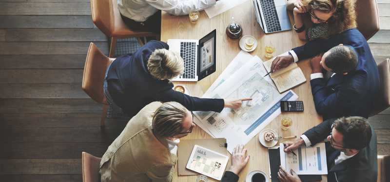 Professionals sitting around a table looking at graphics.