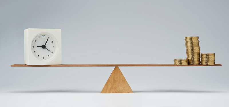 Seesaw with clock on one end and stacks of coins on the other.