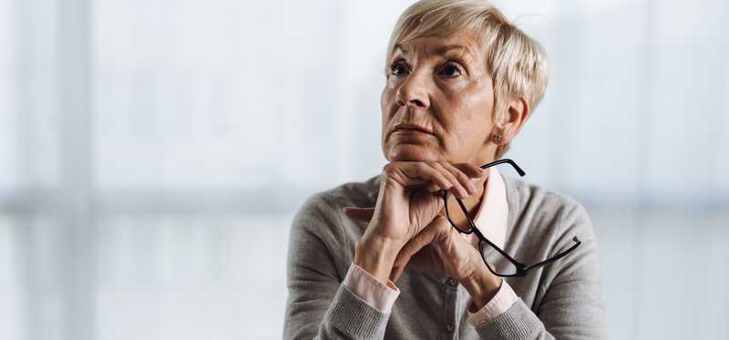 Person stares off to side while at desk in office.