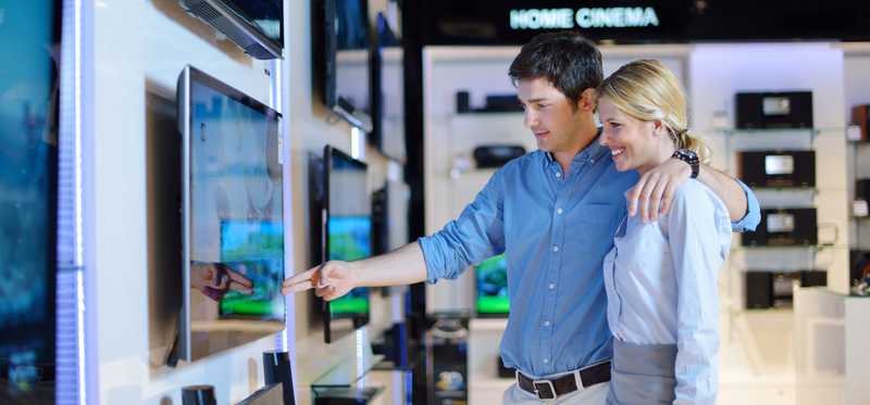 A couple shopping for a TV at an electronics store