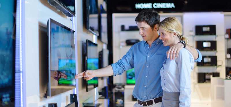 Two people shopping for a TV at an electronics store.