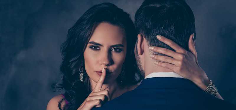 Two people with one putting finger to lips.