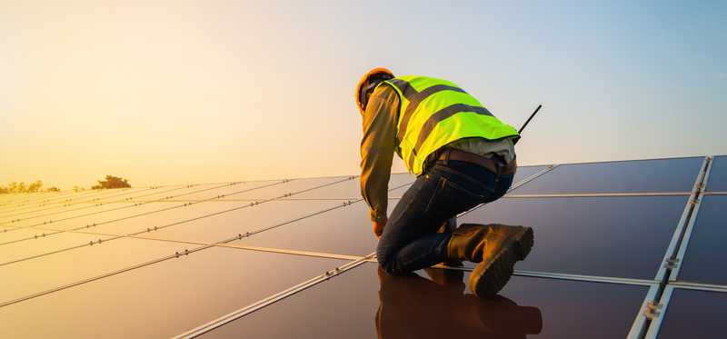Worker installing solar roof panels