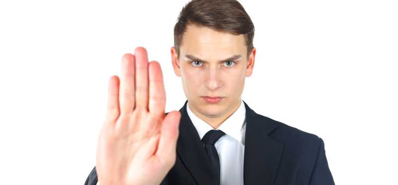 Businessperson holding hand in stop signal.