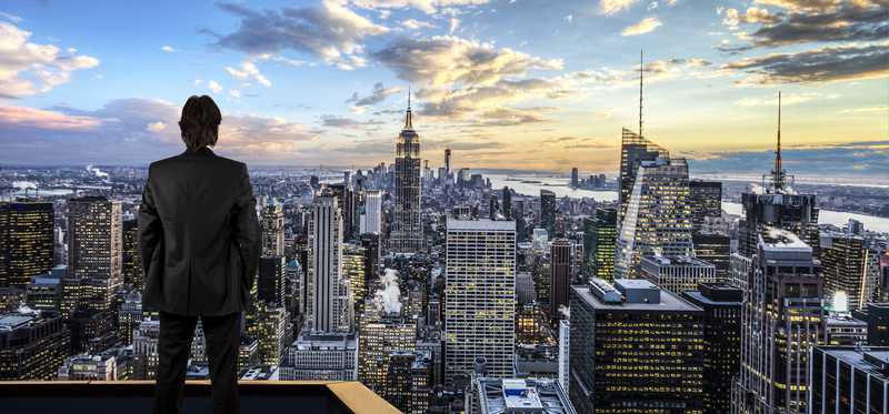 Person on rooftop looking downtown over New York City and the Empire State Building.