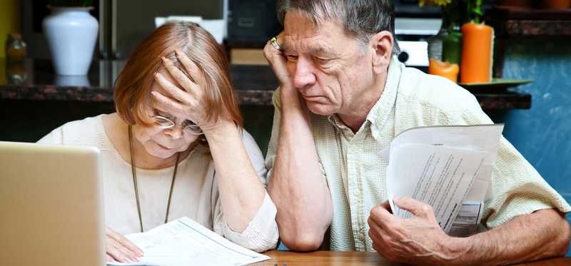 Two people going over paperwork and looking distressed.