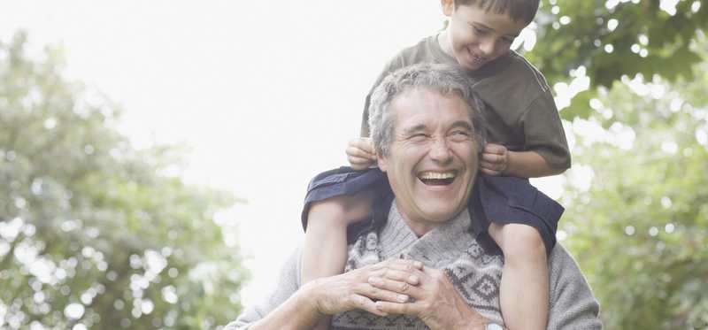 Older man with young boy on his shoulders.