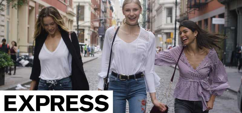 An Express ad campaign with three female models in Express clothing in a city street