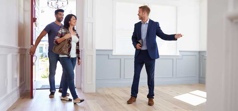 Couple house hunting with a real estate agent.