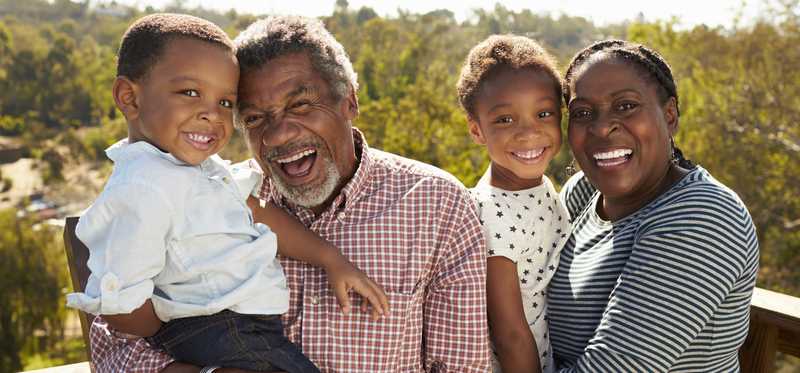 A family of four smiling for the camera.