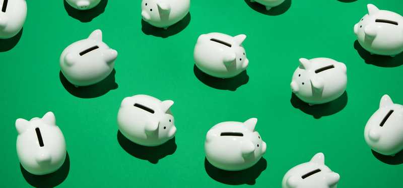 Several piggy banks on a green background.