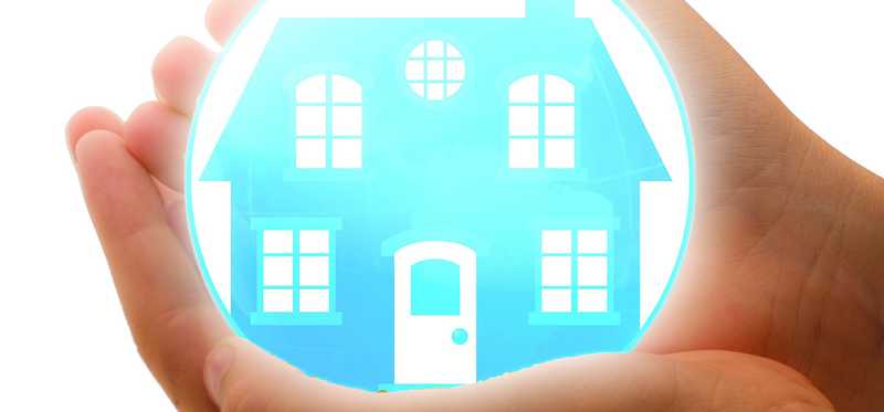 Hands hold a bubble with an illustrated house inside it.