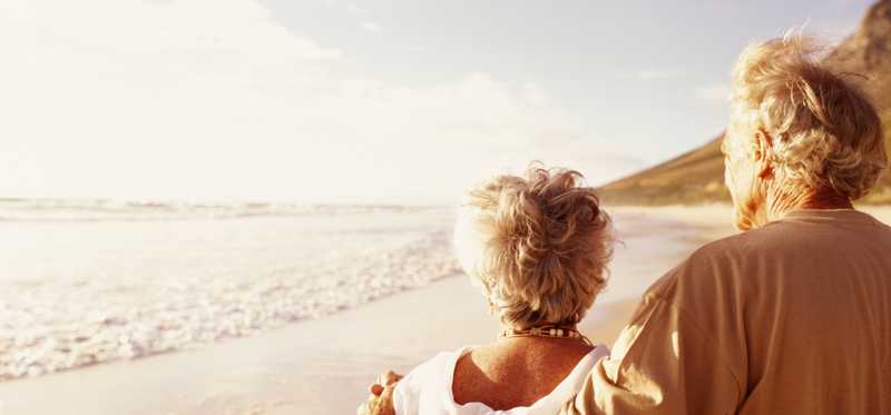 An elderly couple walking on the beach