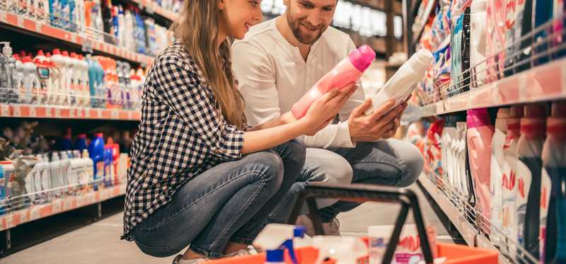 Young couple picks out cleaning products in a store aisle.