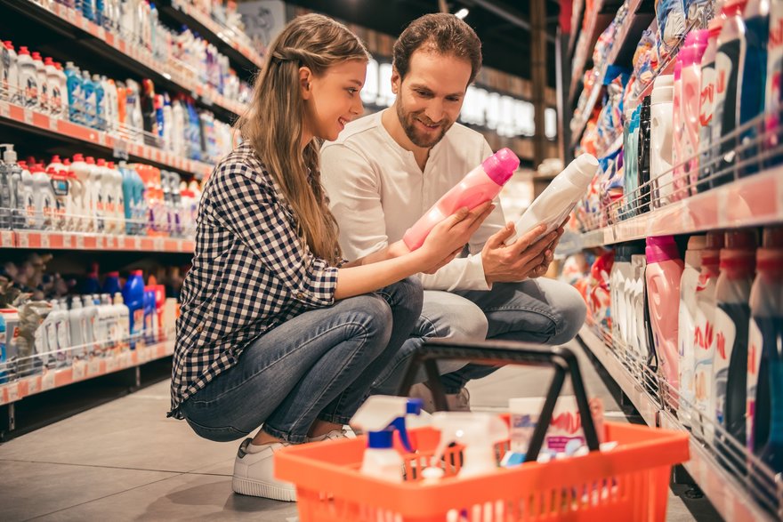 Young couple picks out cleaning products in a store aisle.