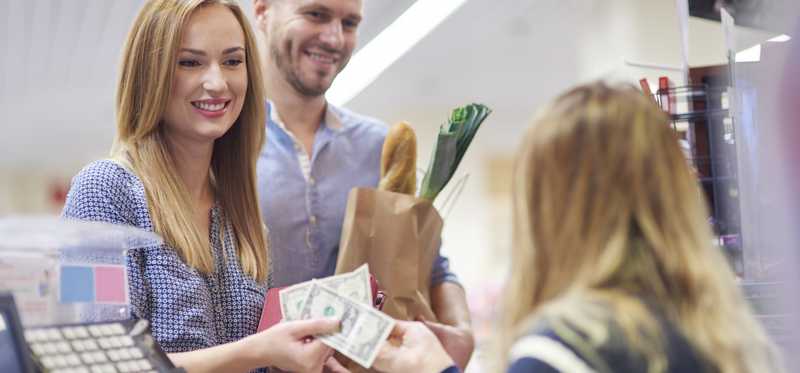 A young couple checks out at the grocery store.