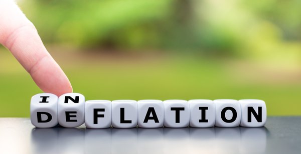 Dice spelling out Deflation being turned over to say Inflation.
