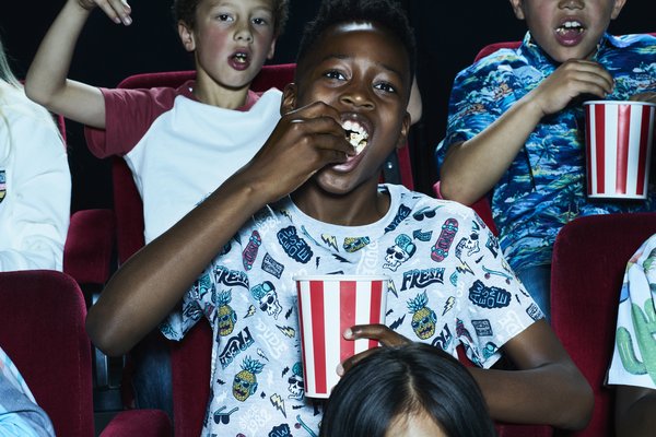 Children eating popcorn in a movie theater.
