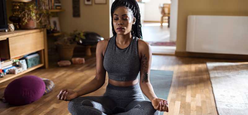 Person meditating on yoga mat.