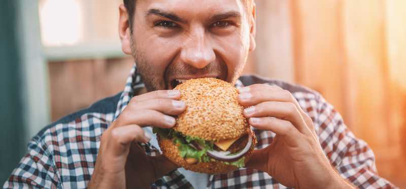 Man biting into a burger.