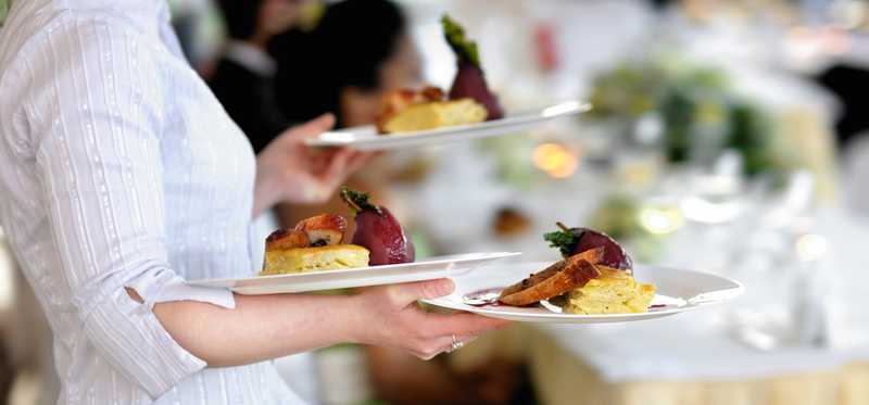 A waitress carrying plates of food.