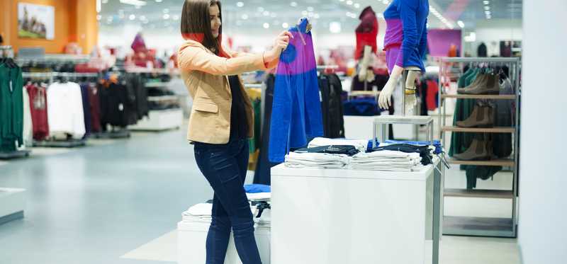 Woman shops from a clothing display.