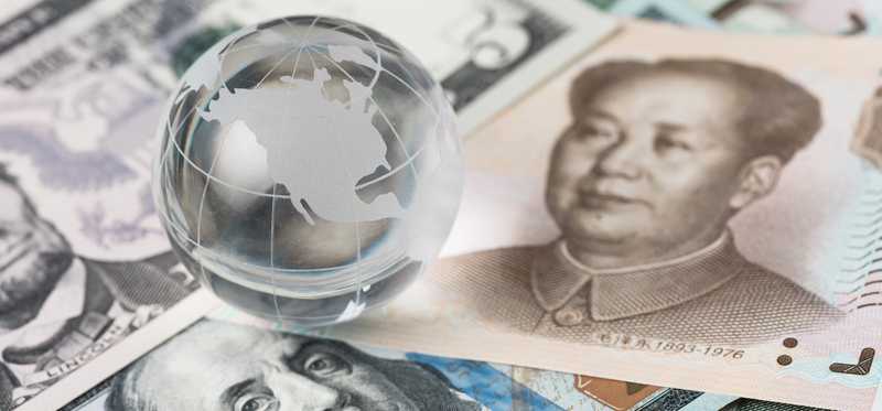 Glass globe on top of U.S. and Chinese currency.