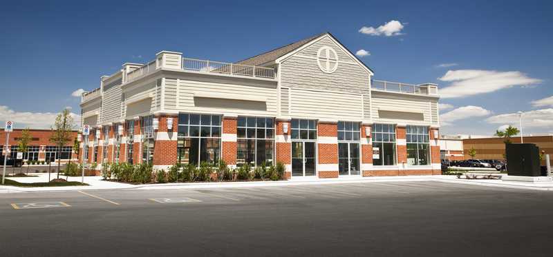 A larger commercial property with a strip mall in the background.