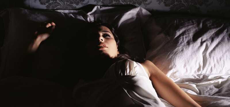 Woman lying in bed with eyes open unable to sleep