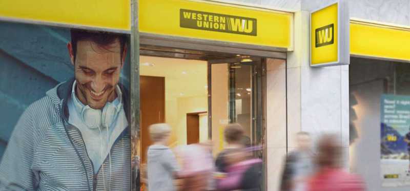 Busy sidewalk outside a Western Union storefront.