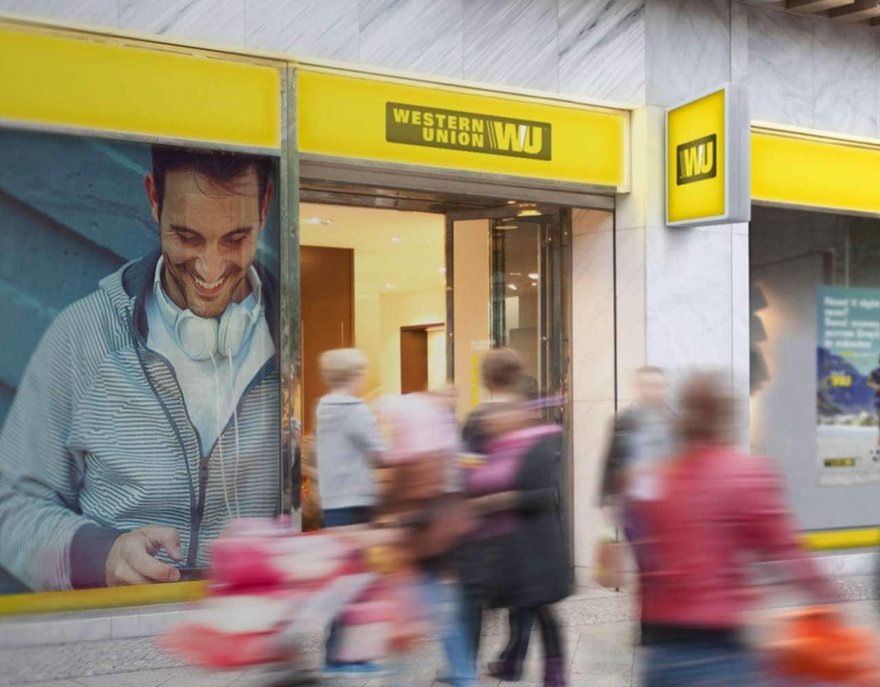 Busy sidewalk outside a Western Union storefront.