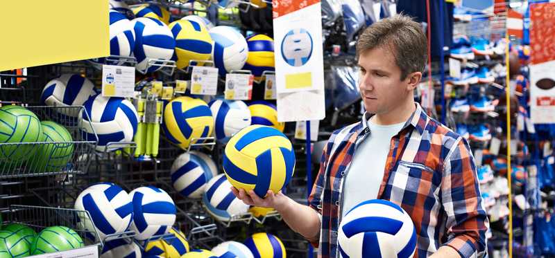 Person in sporting goods store trying out different balls.