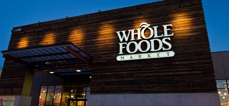 The exterior of a Whole Foods store at dusk.