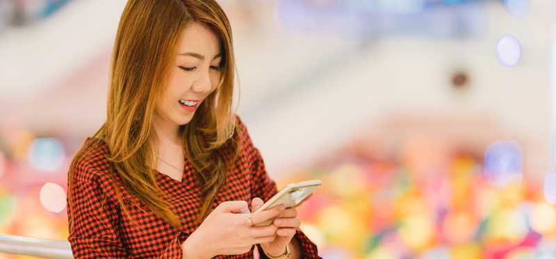 Person smiling while looking at smartphone.