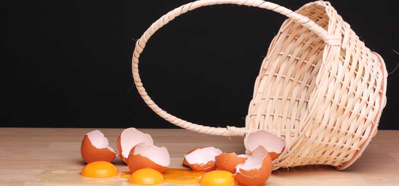 Broken eggs falling out of a basket.