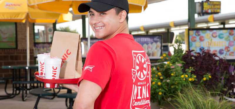 A Sonic employee delivering a meal.
