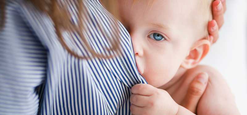 An infant breast feeds.