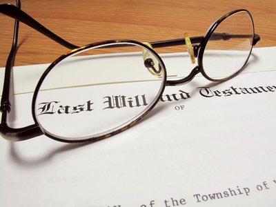 A last will and testament document with reading glasses on top of it.