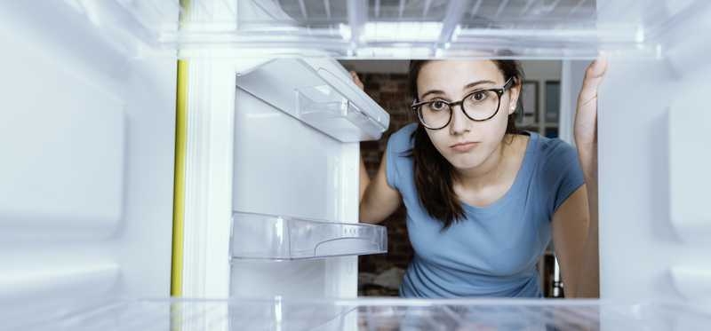 Person looking in empty refrigerator.