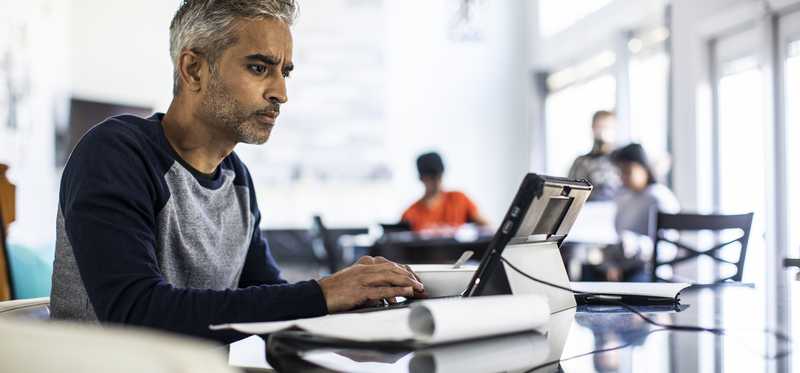 Person looking intently at laptop screen in office.