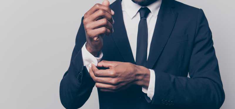 Man adjusting the cuffs of his suit.