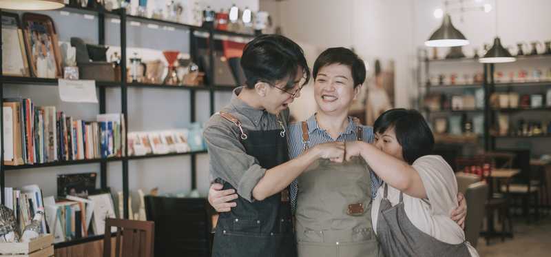 Three people in a small mom-and-pop retail shop.