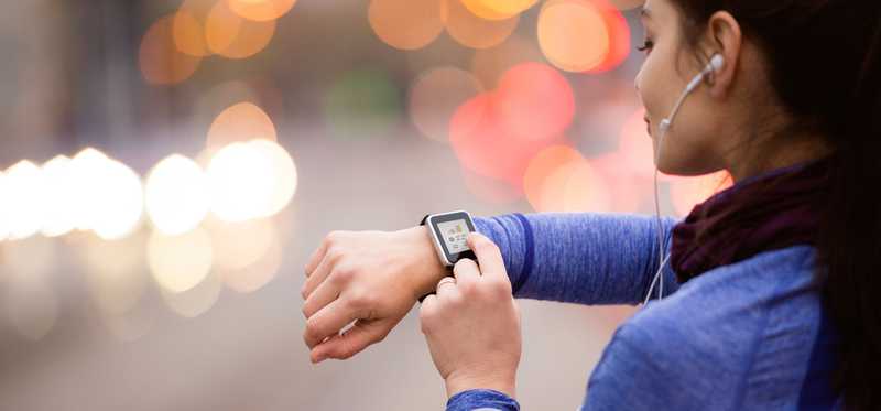 A woman checks her smartwatch.