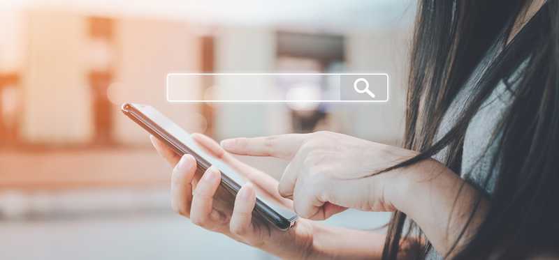 Woman holding phone and using search engine